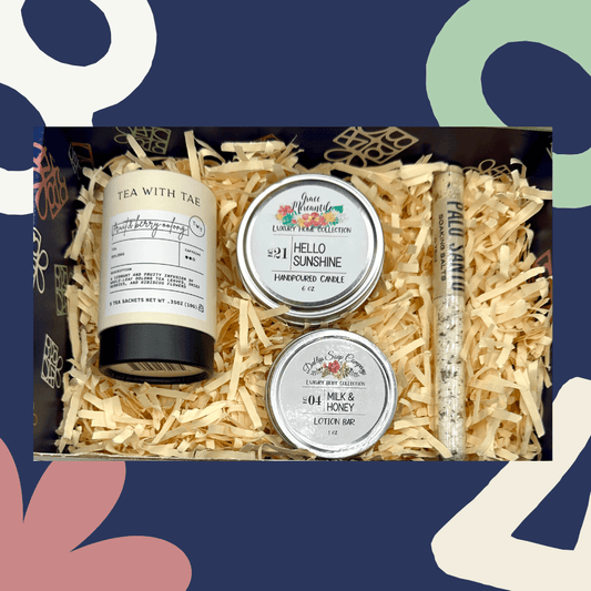 Gift set with tea, candles, and lotion bars in a decorative box against a colorful abstract background.
