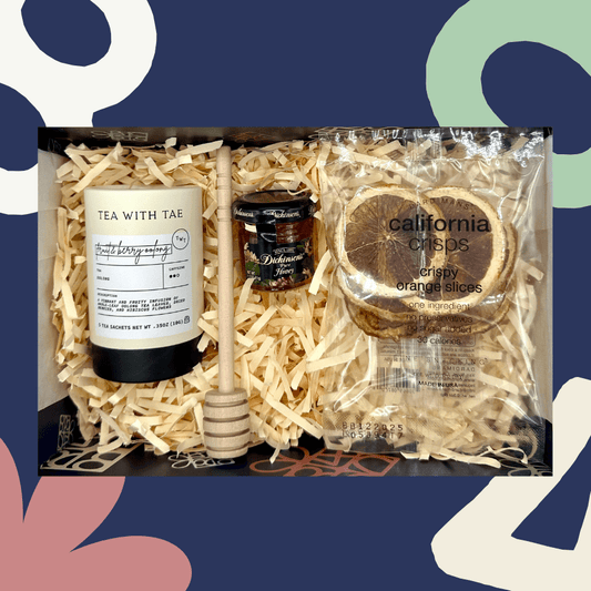 Gift set with tea, honey, and orange slices on a decorative background
