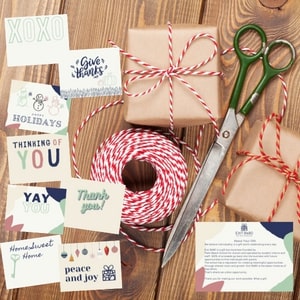 Gift wrapping supplies including paper, ribbons, and scissors on a wooden surface.