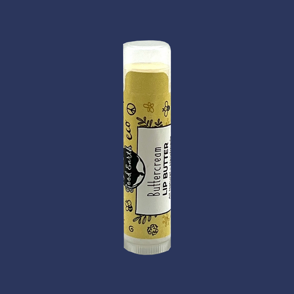 A tube of Good Earth Lip Butter – Buttercream with a yellow label and branding details.