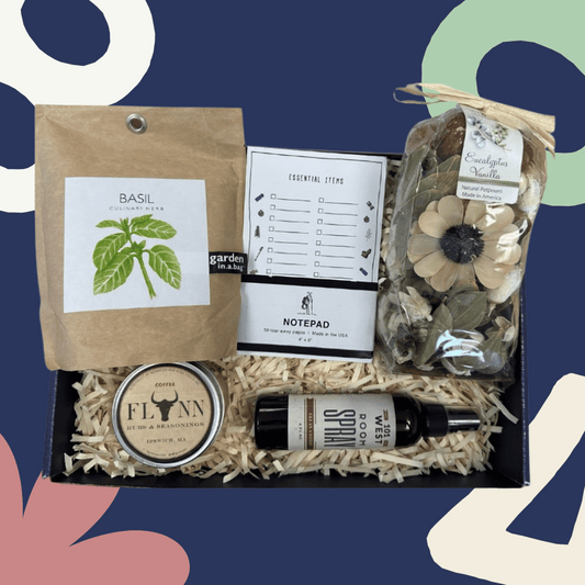 Gift box with basil seed packet, notepad, and other items on a blue background