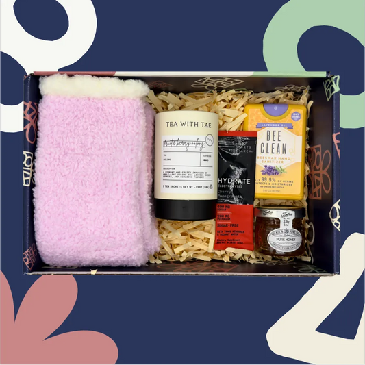 Gift box with pink fuzzy socks, tea, and other products on a colorful background