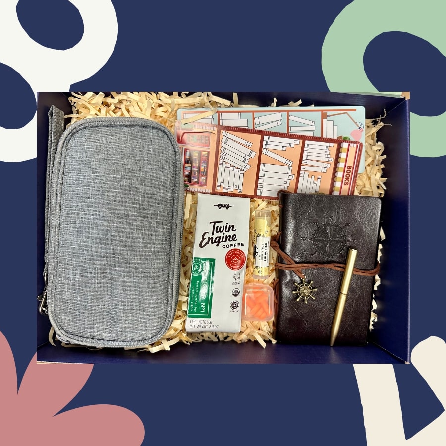 Gift box with a gray pouch, notebook, and other items on a blue background