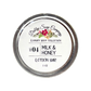 lotion bar with milk and honey scent; packaged in a circular tin can; show top down