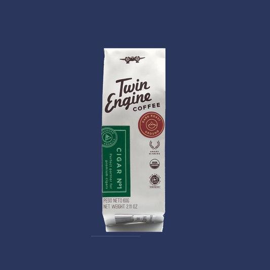 A packaged product labeled 'Twin Engine Coffee' which is a dark roast coffee, with additional details about the product, such as 'Cigar Mild', '100% Arabica', and 'Grown in Nicaragua'. The packaging is primarily white with green and brown accents.